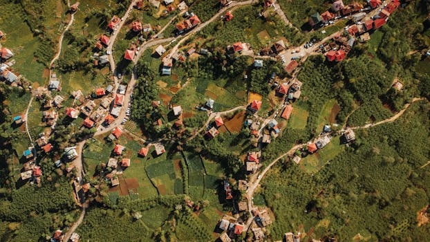 Drone shot of a scenic rural village with vibrant fields and houses, showcasing a peaceful countryside.